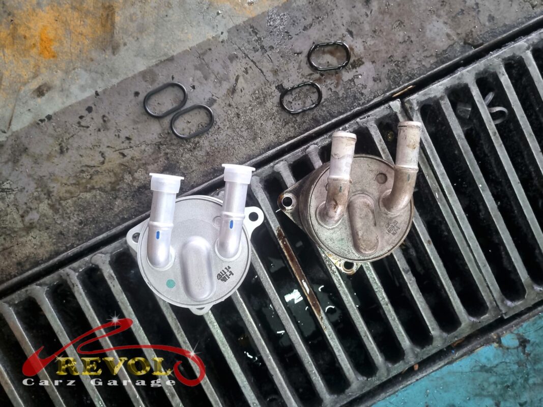 The new BMW-spec oil cooler (left) next to the old one (right), with the old and new gasket O-rings between them.