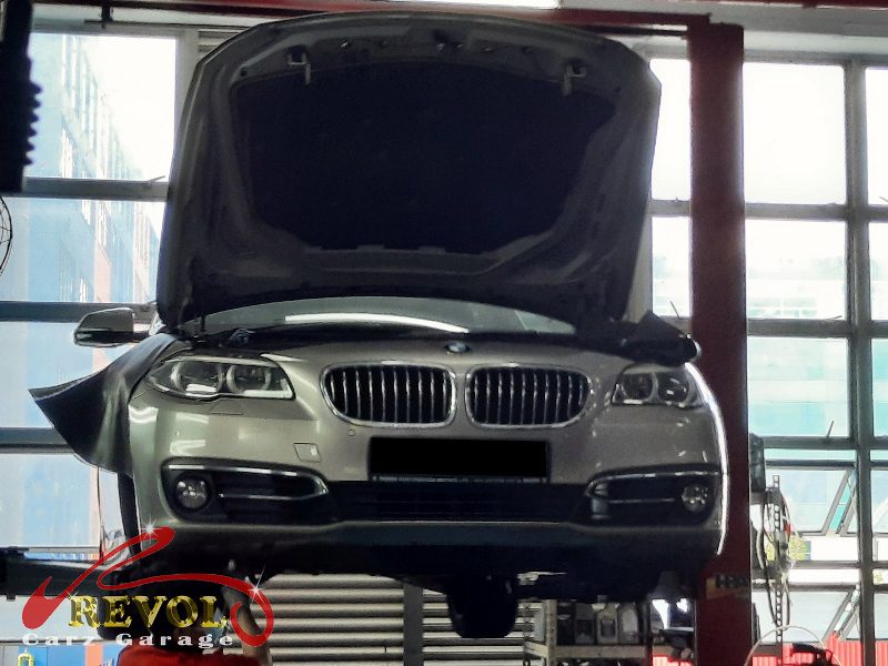 The worn front shock absorber on the BMW 520i, weeping and weak.