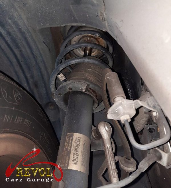 The old front struts removed alongside the new pair.