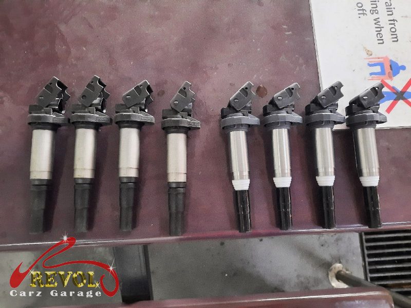 The old ignition coils removed alongside the worn plugs.