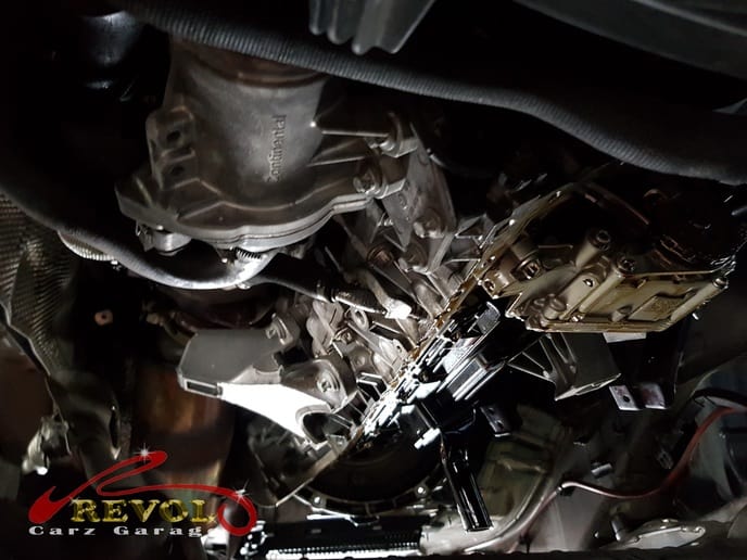 The metal oil sump being removed to reach the gasket.