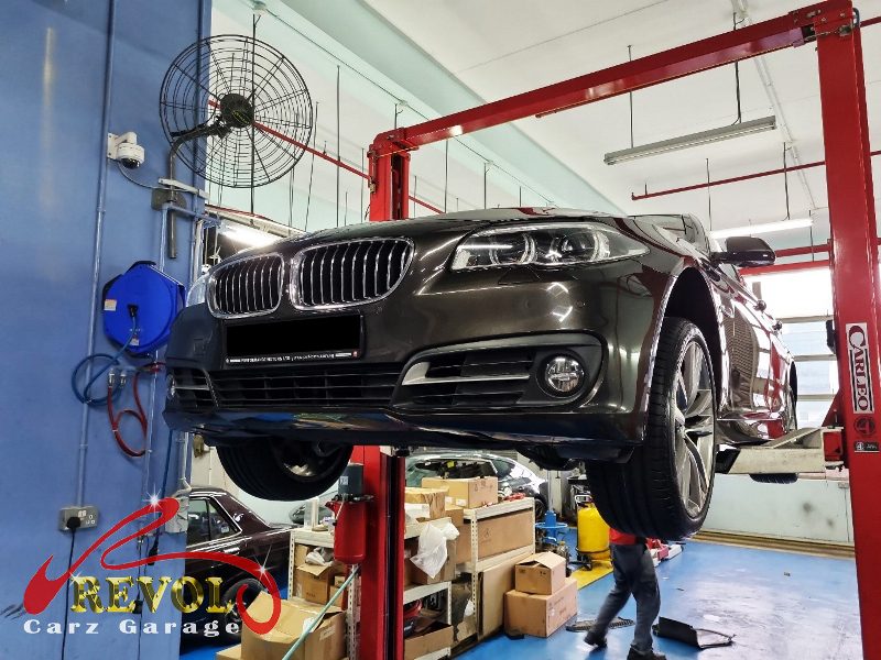 The BMW 528i on the lift, the rattle tracked to a loose undercarriage cover.