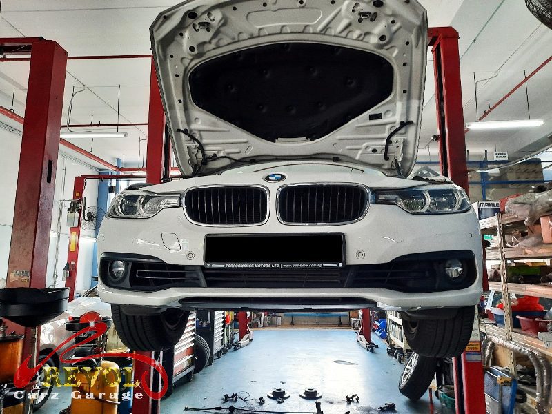 The worn front pads and scored disc on the BMW 318i.