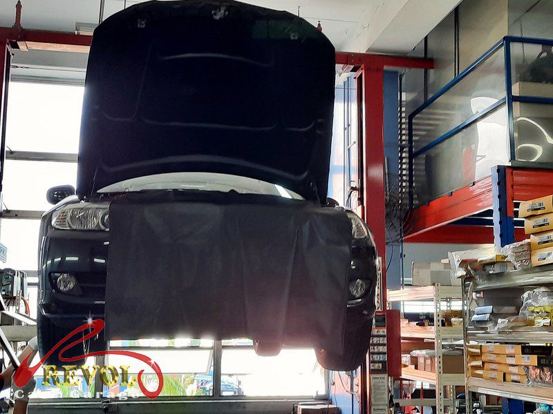 The worn front shock absorber on the BMW 318i, weeping and weak.