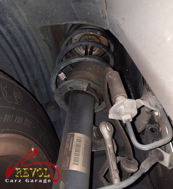Both old front struts removed and lined up against the new pair.