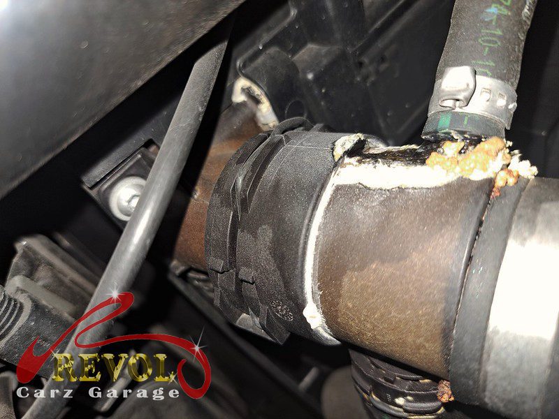 The old cracked coolant expansion tank removed from the engine bay.