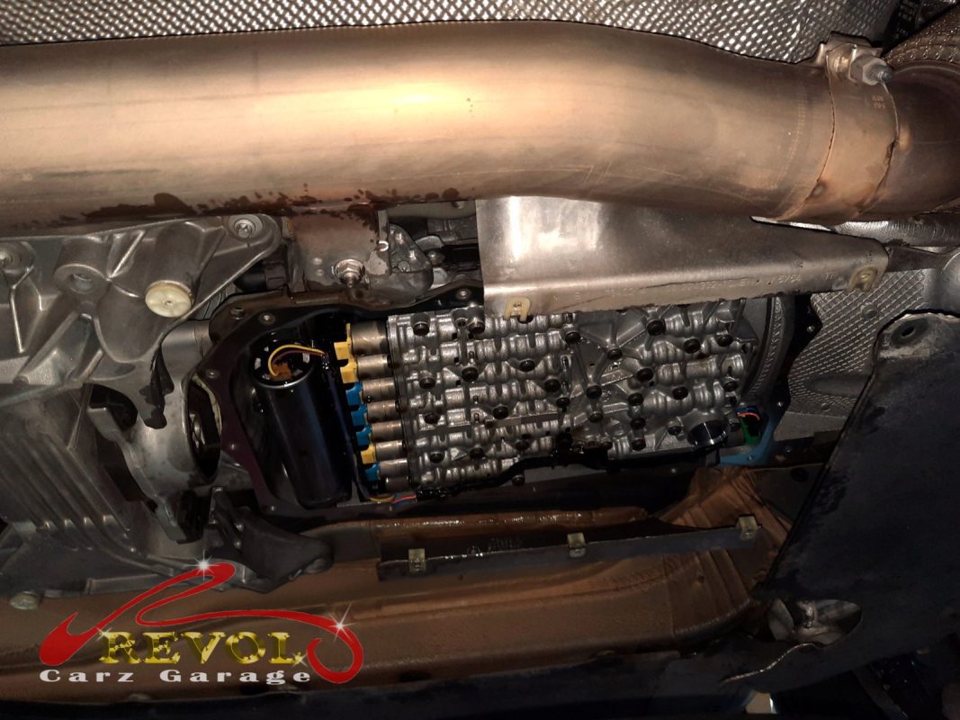 The transmission pan dropped showing the old pan-and-filter assembly.