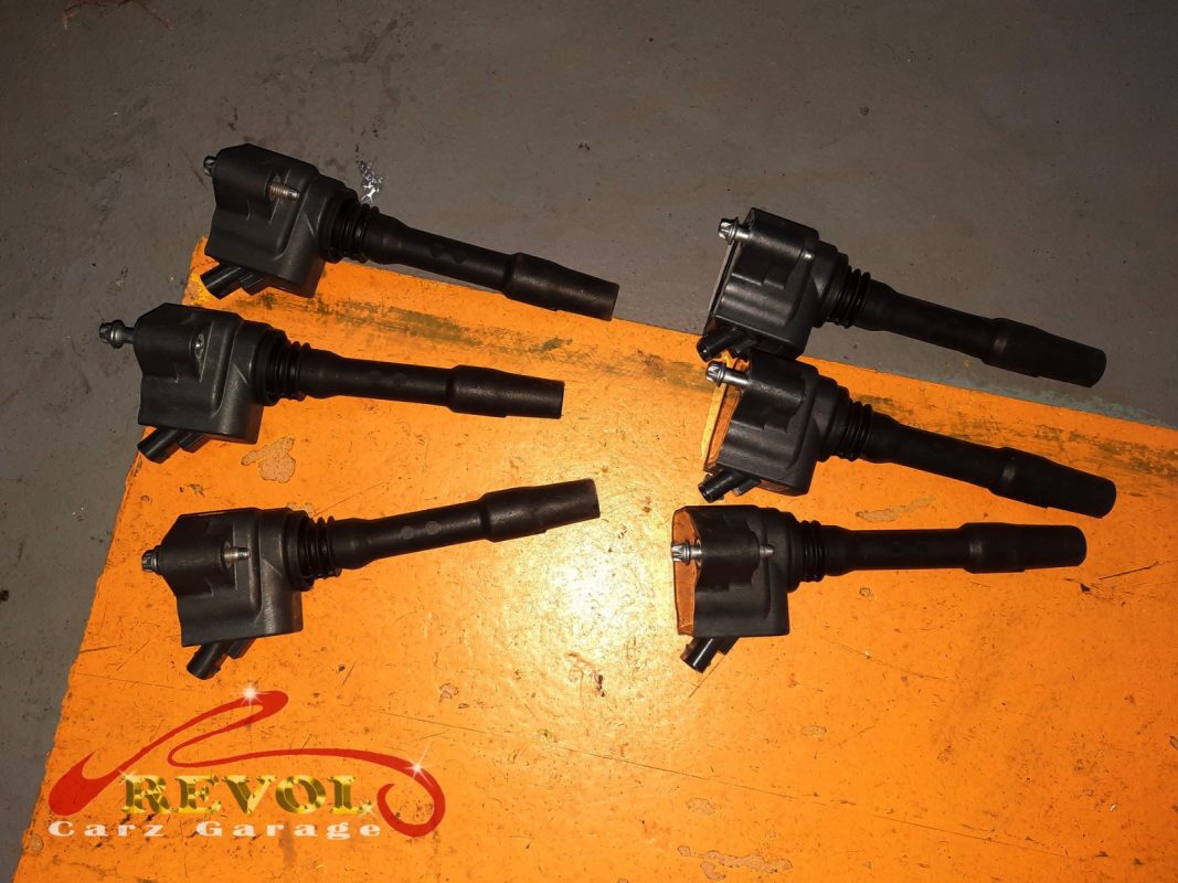 The old worn ignition coil and spark plug removed.