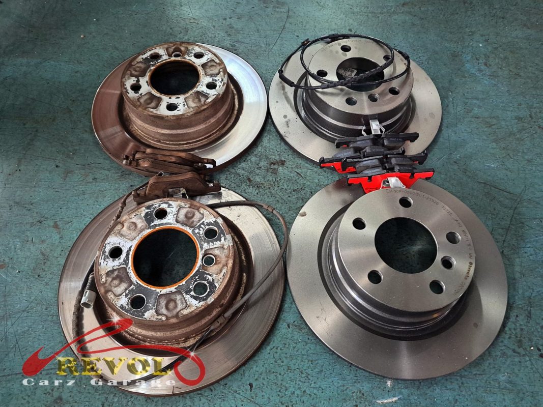 The worn front disc beside the new BMW-spec rotor.