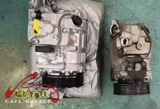 The old AC compressor removed from the engine.