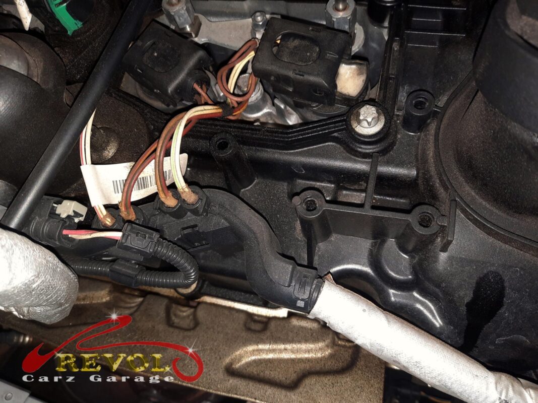 The ignition coils removed and the old warped valve cover exposed.