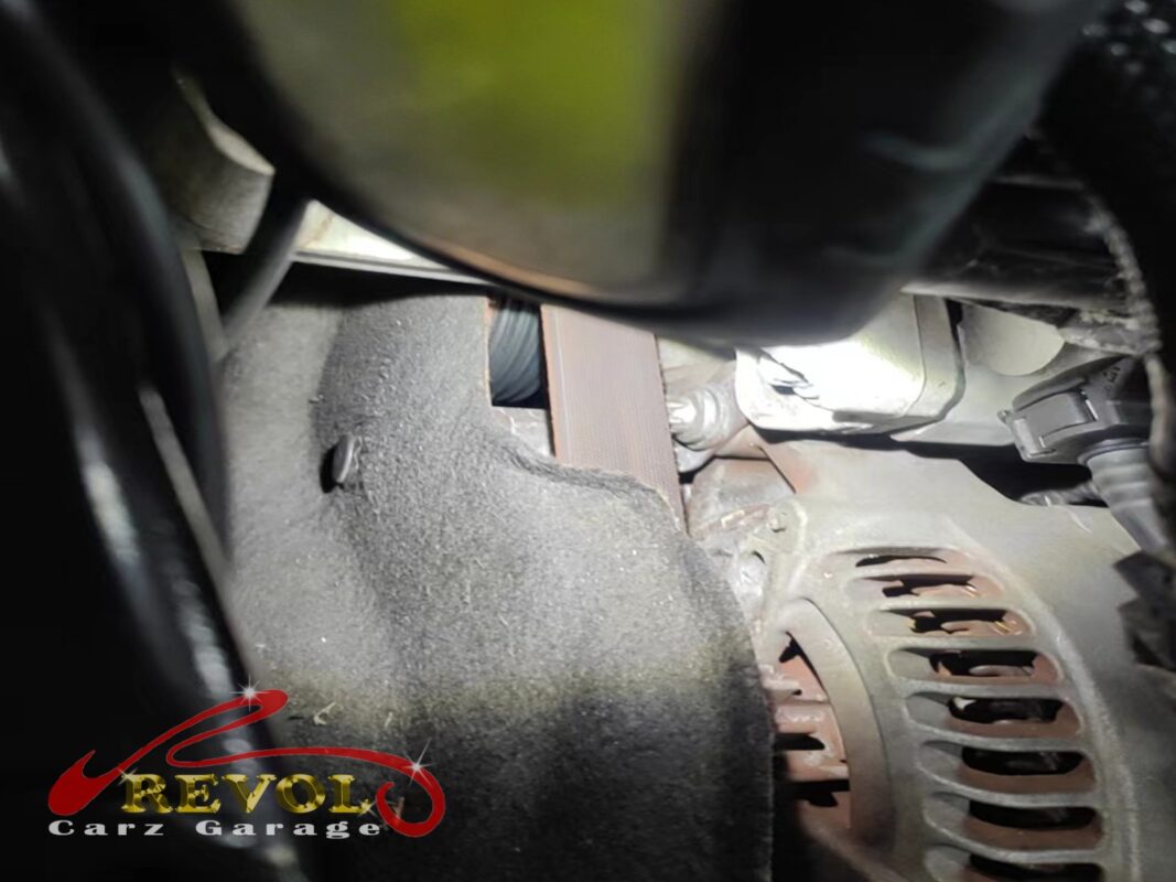 The worn accessory belt routed around the pulleys on the BMW 216d.