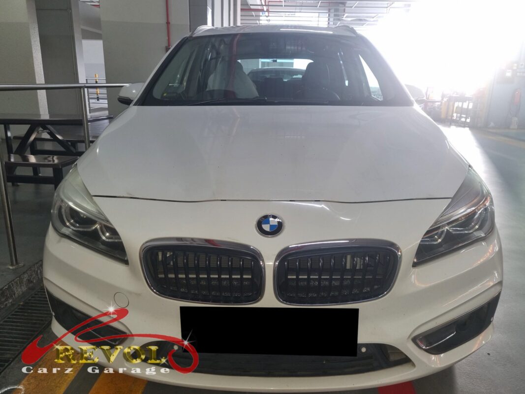 BMW 216d with the engine bay open for water pump housing replacement.