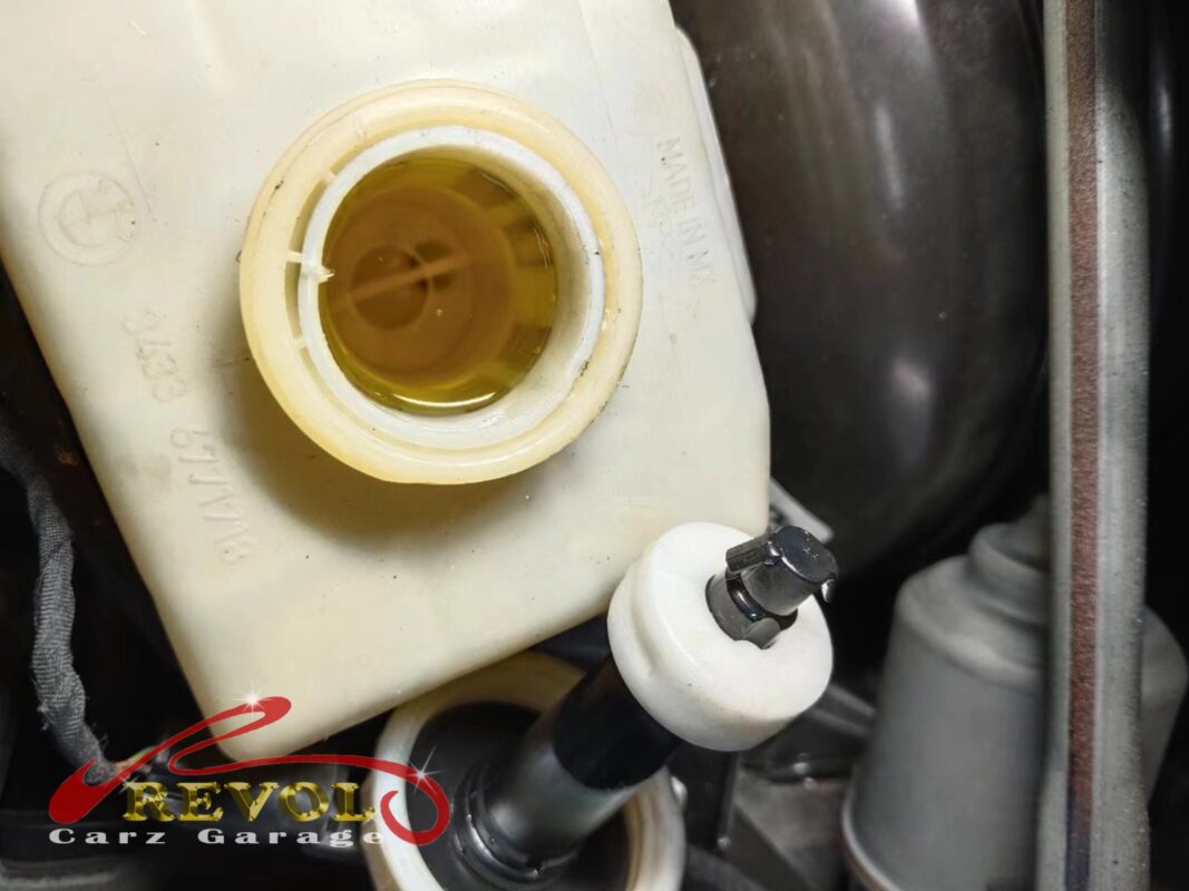 The brake fluid reservoir, cap off, the fluid topped to the line as part of the brake service.
