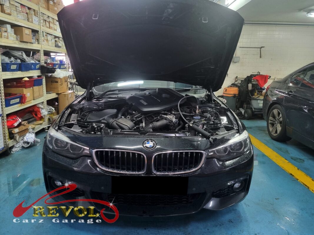 BMW 420i with the engine bay open for thermostat housing replacement.