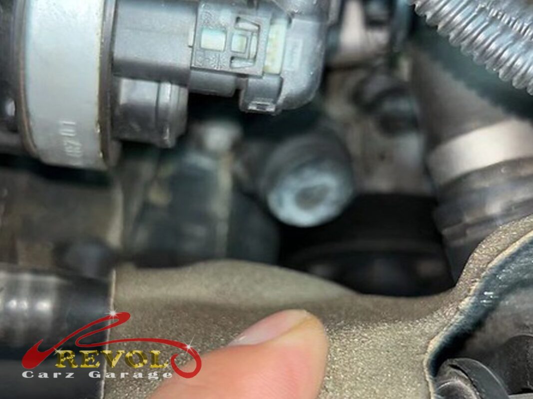 The thermostat housing on the engine, the spot where coolant had been weeping picked out by hand.