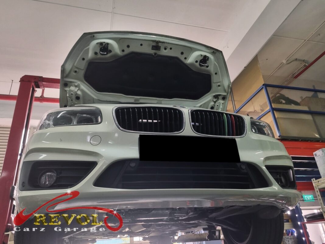 The BMW 216i up on the two-post lift, in to track down the burning smell and the oil loss.