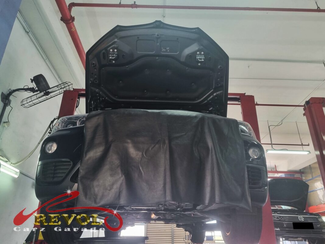 The BMW X1 up on the two-post lift, fender cover on, in for its routine maintenance interval.