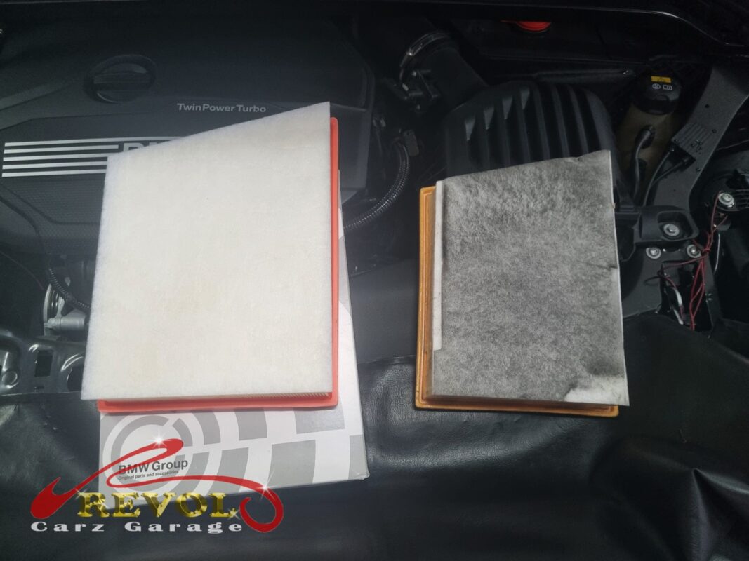 The old engine air filter (right, grey and dirty) next to the new BMW-spec one (left, still on its box).