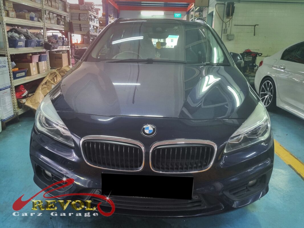 BMW 216d with the engine bay open for water pump replacement.