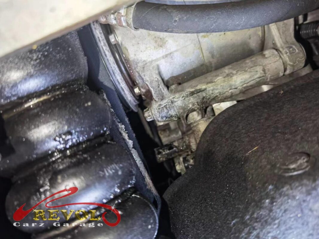 White crusty coolant residue around the water pump area, where the shaft seal had been weeping and drying onto the housing.