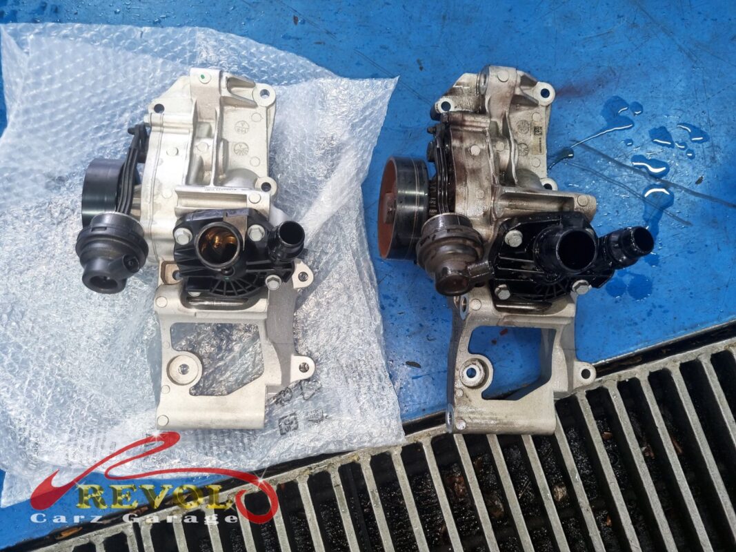 The new BMW-spec water pump (left) next to the old one (right), grimy and weeping at the shaft seal.