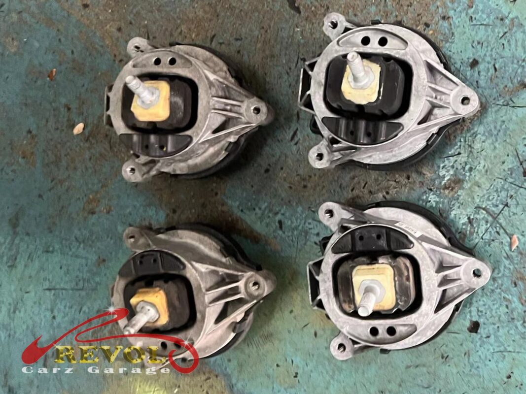 Engine mounts laid out, the round hydraulic units with the cream rubber visible inside.