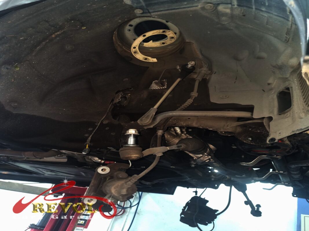 The front end partly stripped, the subframe, steering rack and suspension arms in view, the brake hub off.