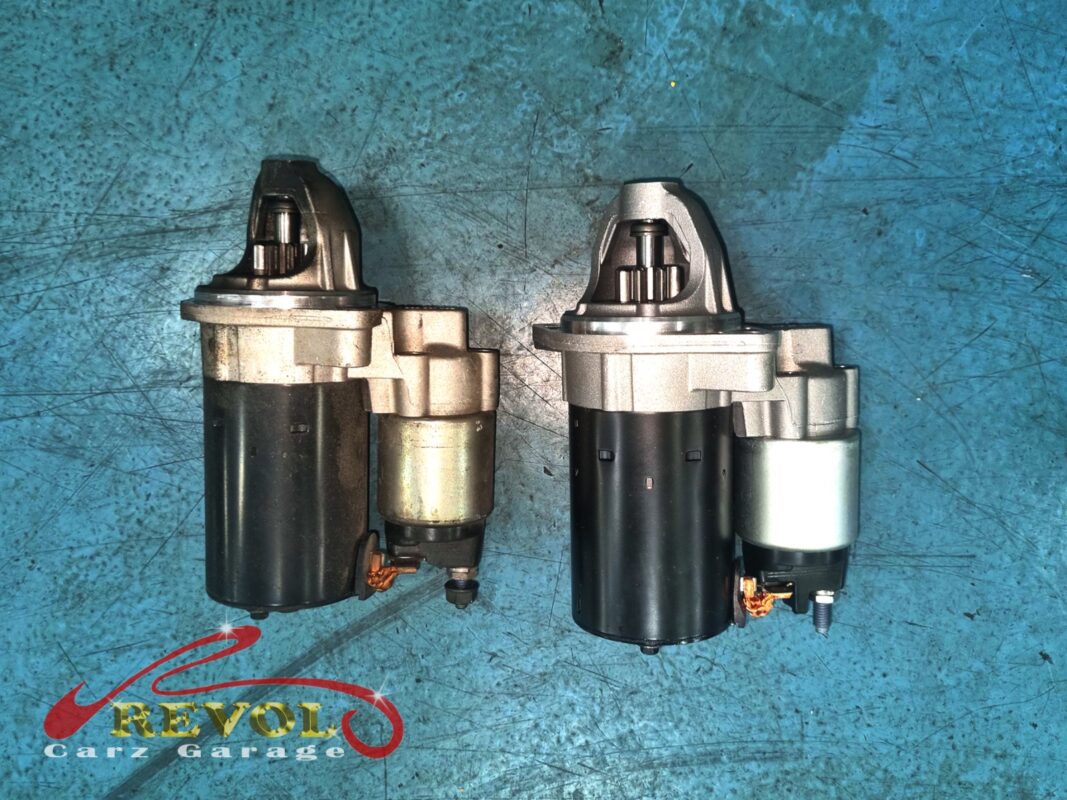 The old starter motor (left, grimy) next to the new BMW-spec replacement (right).