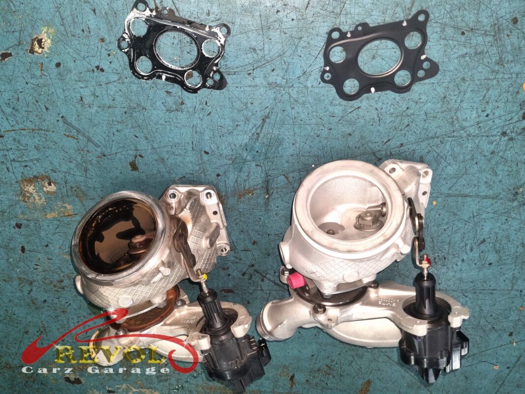 Failed turbocharger removed, oil contamination at the seal area visible.