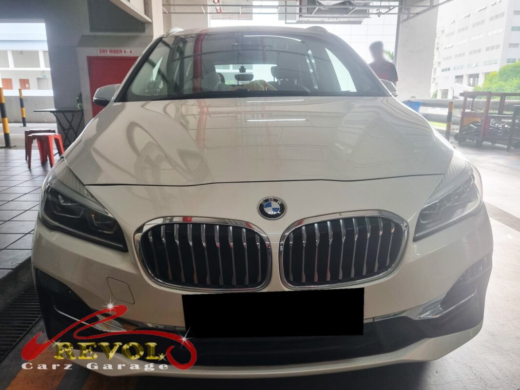 BMW 216i with the bonnet open for washer motor replacement.