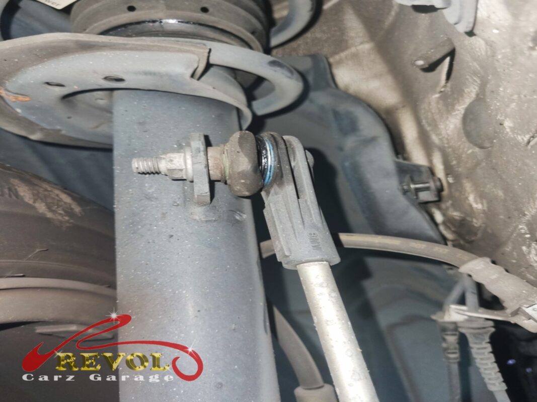 One of the front anti-roll bar drop links still on the car, bolted to the strut, the ball joint worn loose.