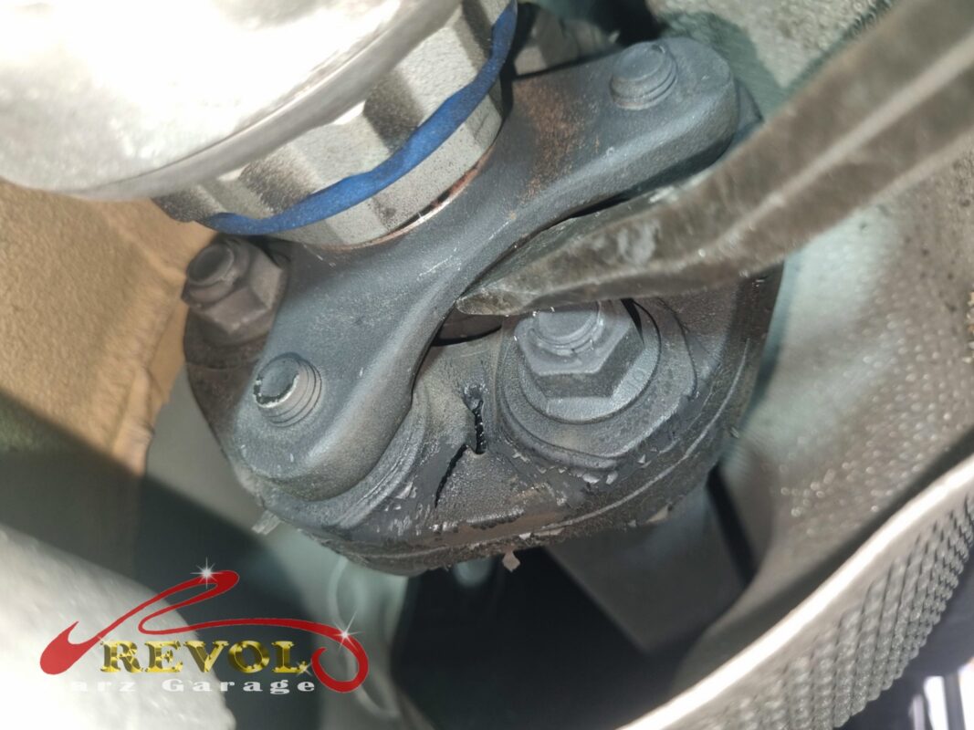 The driveshaft coupling underneath, the rubber of the old flex disc cracked through where the propshaft loads it.