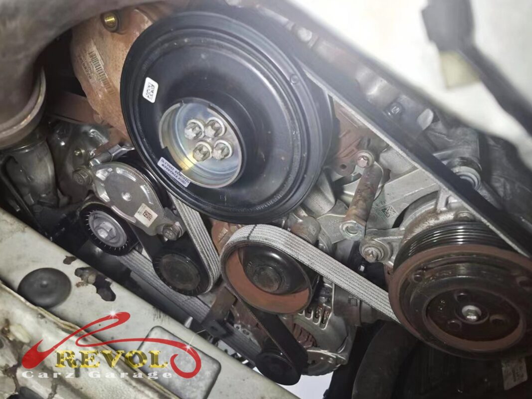 The new BMW-spec crankshaft pulley, belt, tensioner and idlers fitted at the front of the engine.