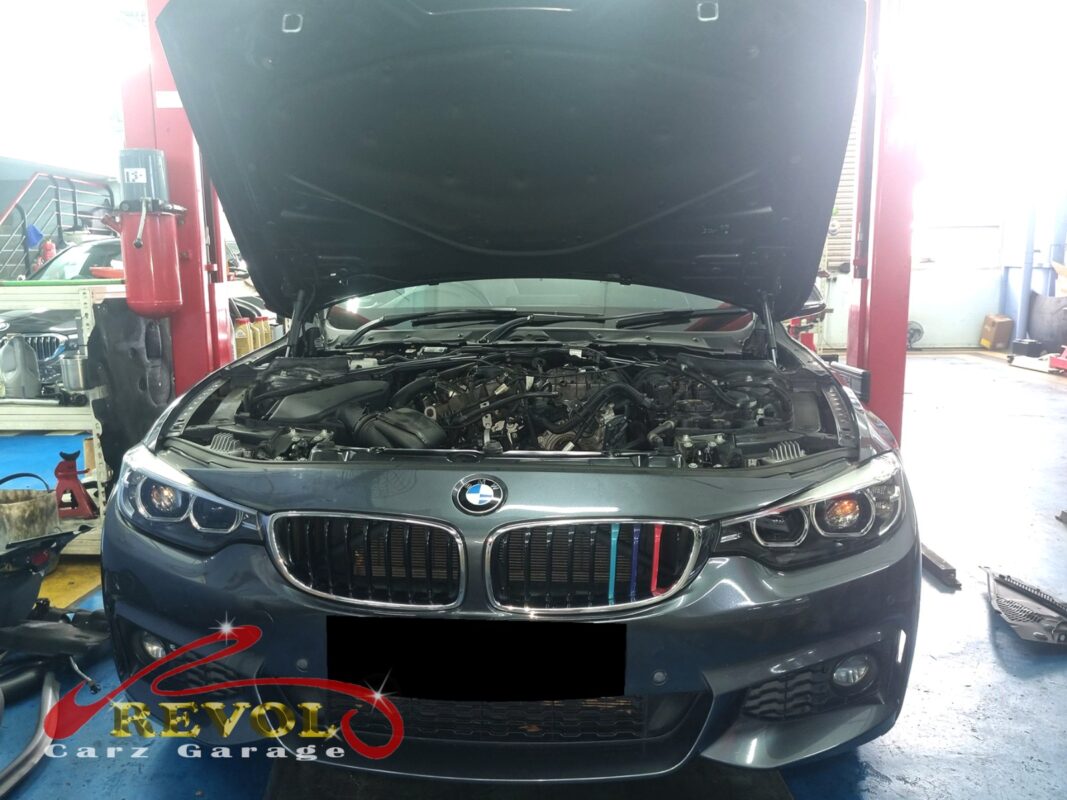 BMW 420i with the engine bay open for oil filter housing inspection.