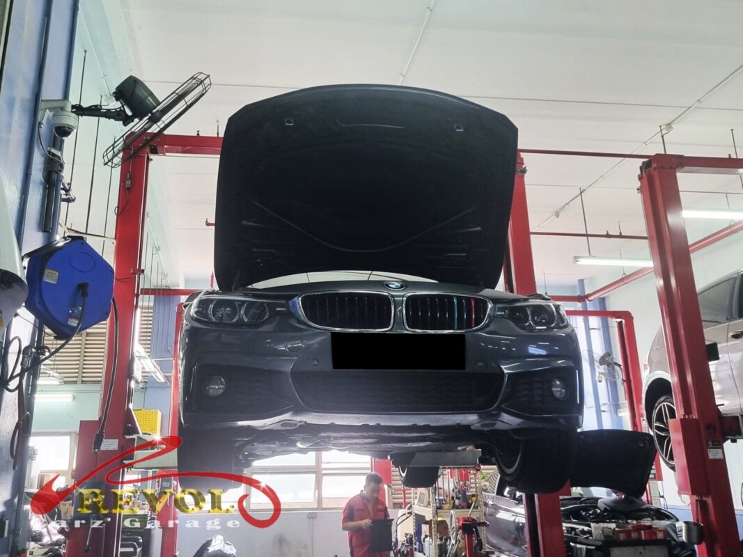 The 420i up on the two-post lift, in for the oil leak.