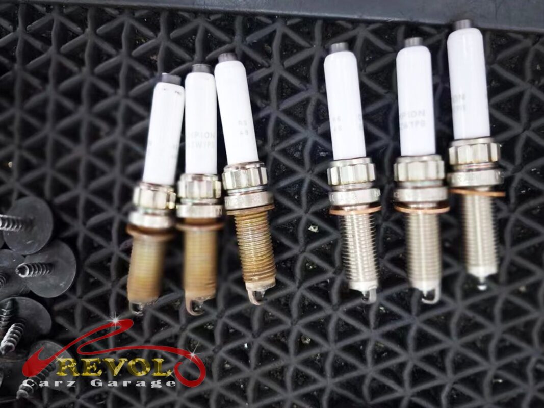 The old spark plugs removed during the service, ready for a fresh BMW-spec set.