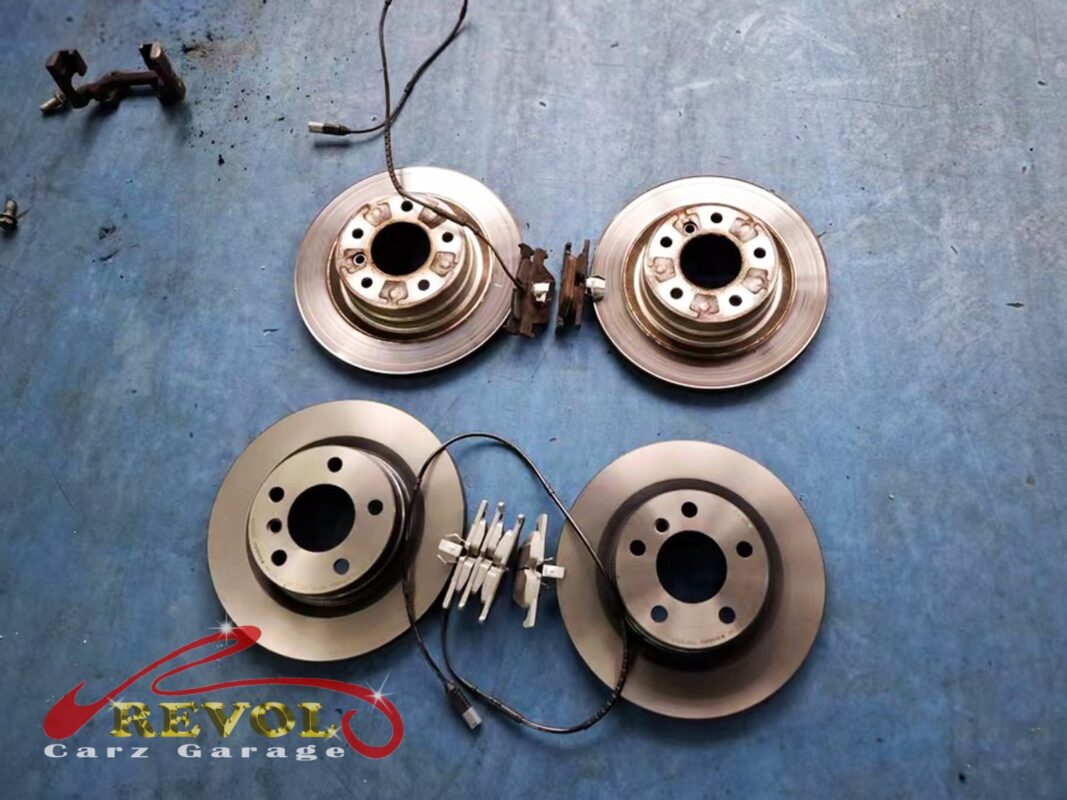 The worn front and rear brake discs and pads (top) replaced with new BMW-spec discs and pads (bottom).