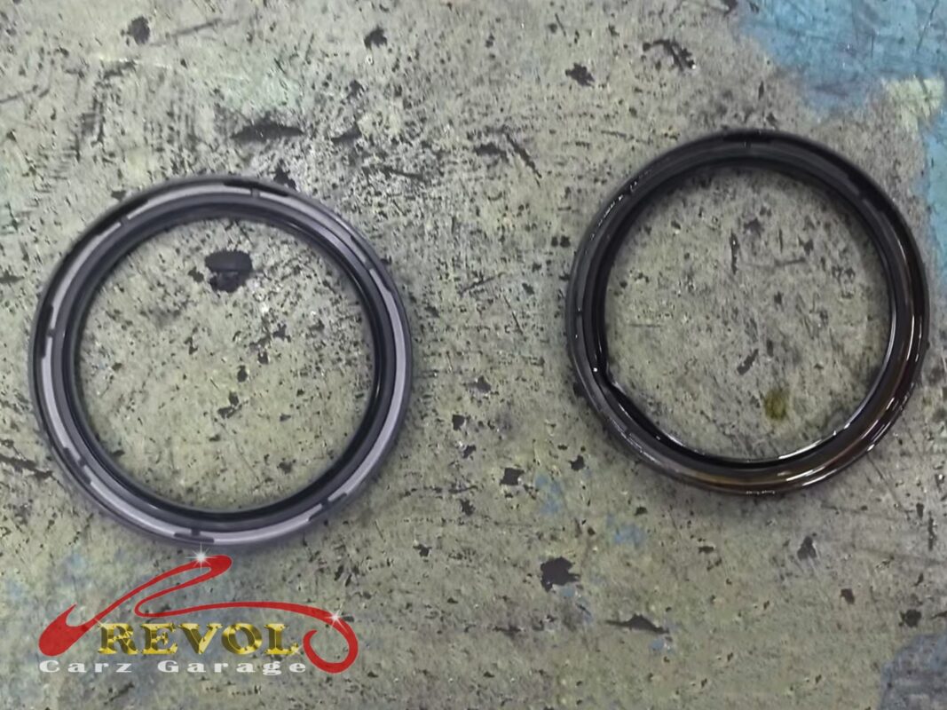The old rear main seal (right), the lip worn and hardened, beside the new BMW-spec replacement (left).