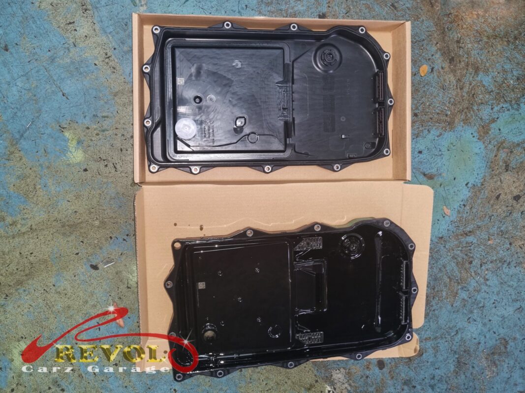 The new BMW-spec ATF pan with its integrated filter (top) next to the old one removed (bottom).