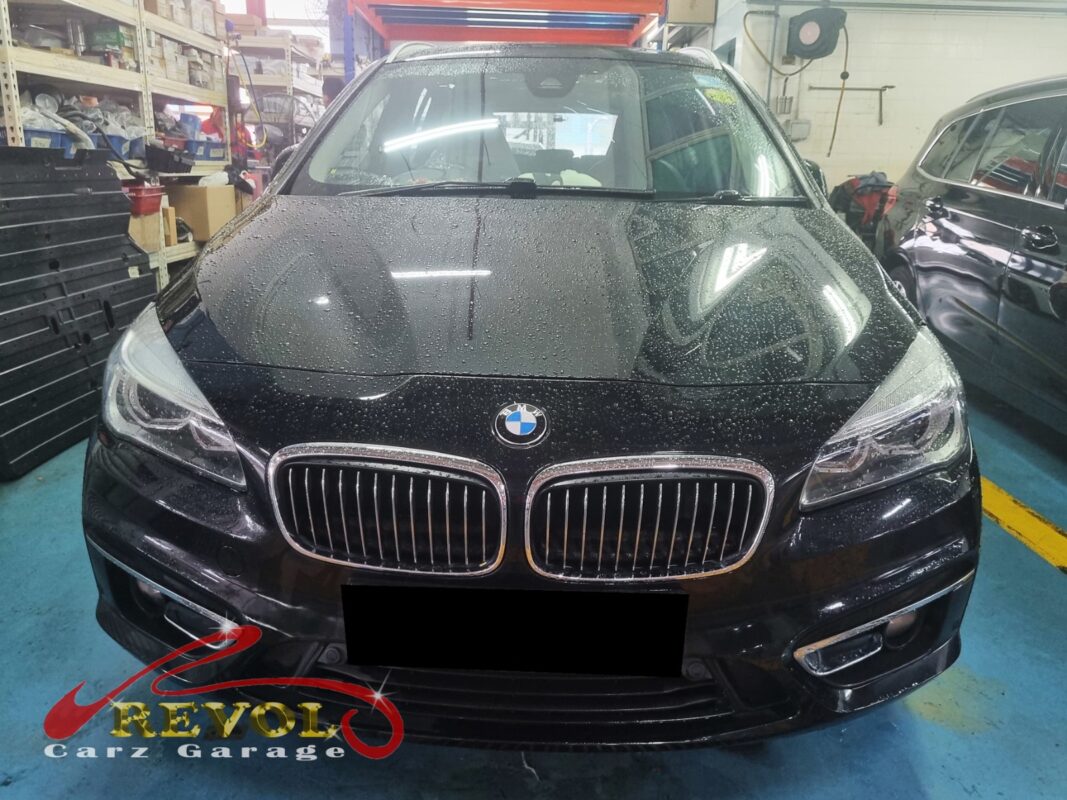 BMW 216d with the engine bay open for oil filter housing inspection.
