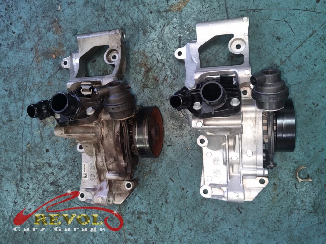 The old water pump module (left, grimy) beside the new BMW-spec replacement (right).