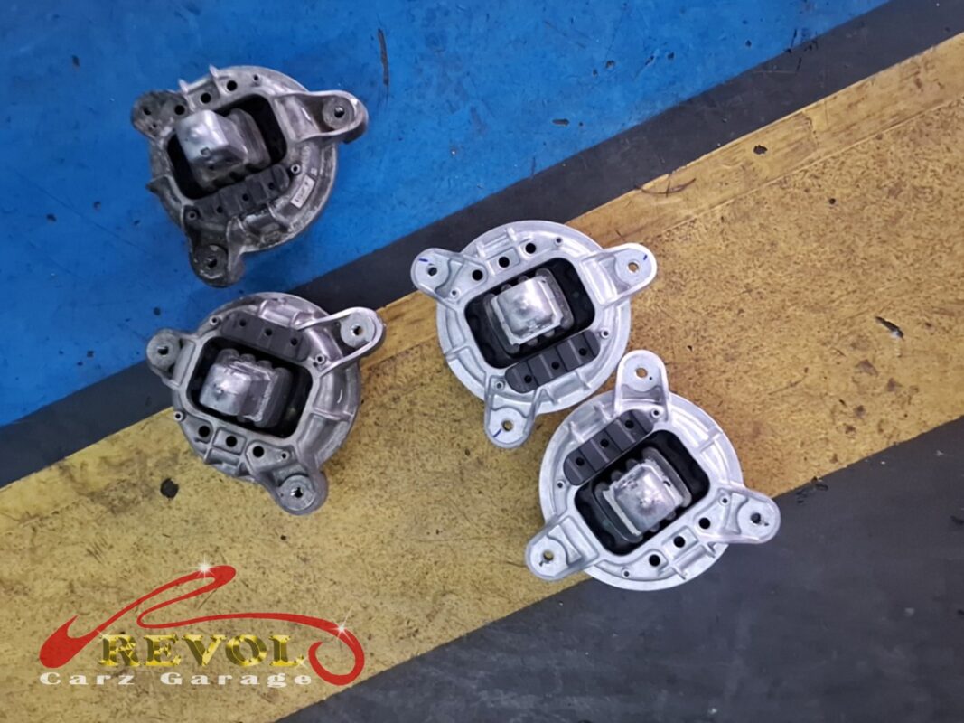 The old engine mounts (left, grimy) beside the new BMW-spec replacements (right).
