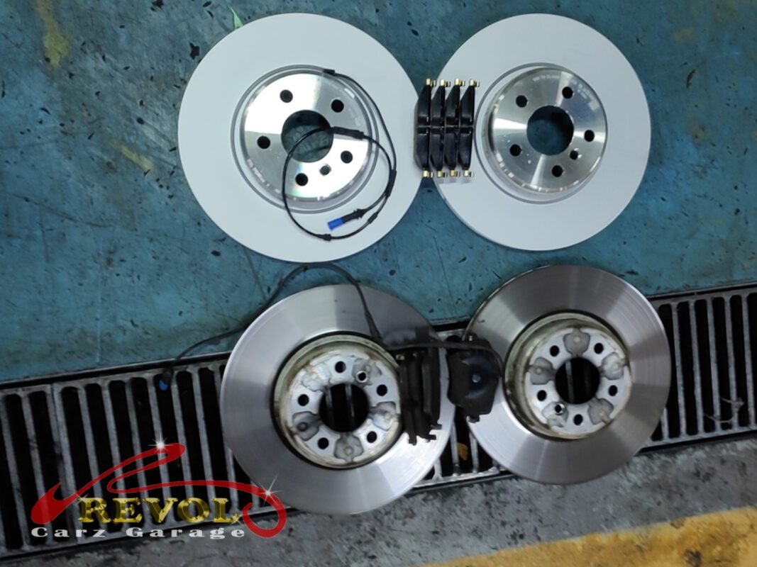 The worn brake discs and pads (bottom) replaced with new BMW-spec discs and pads (top).