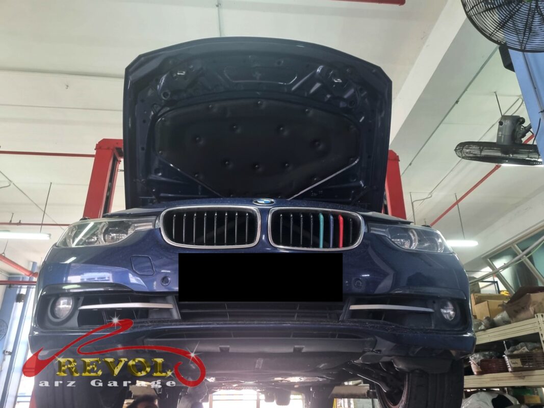 The 318i up on the two-post lift, in to settle the false low-oil warning.