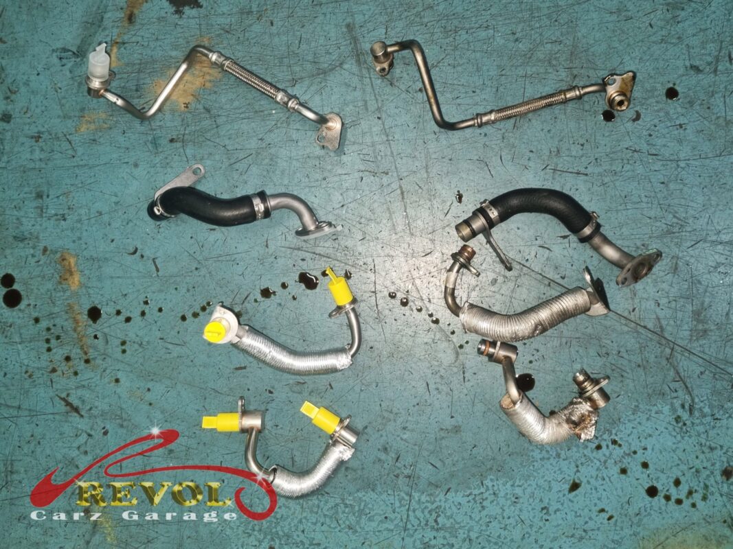 The turbo coolant and oil pipes, the worn ones off the car beside the new BMW-spec replacements with their transit caps.