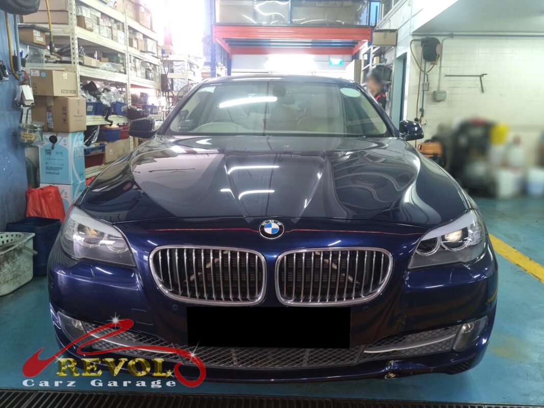 BMW 523i on the workshop lift with both front wheels off for control and lower arm replacement.