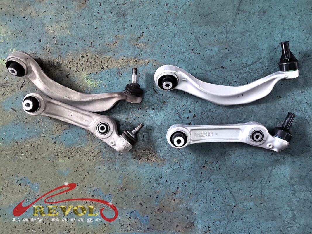 Front suspension arms from the set, the worn ones beside the new BMW-spec replacements.