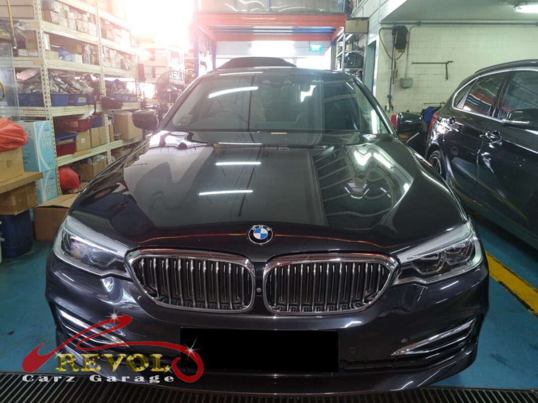 BMW 216d on the workshop lift with the engine bay open for water pump housing replacement.