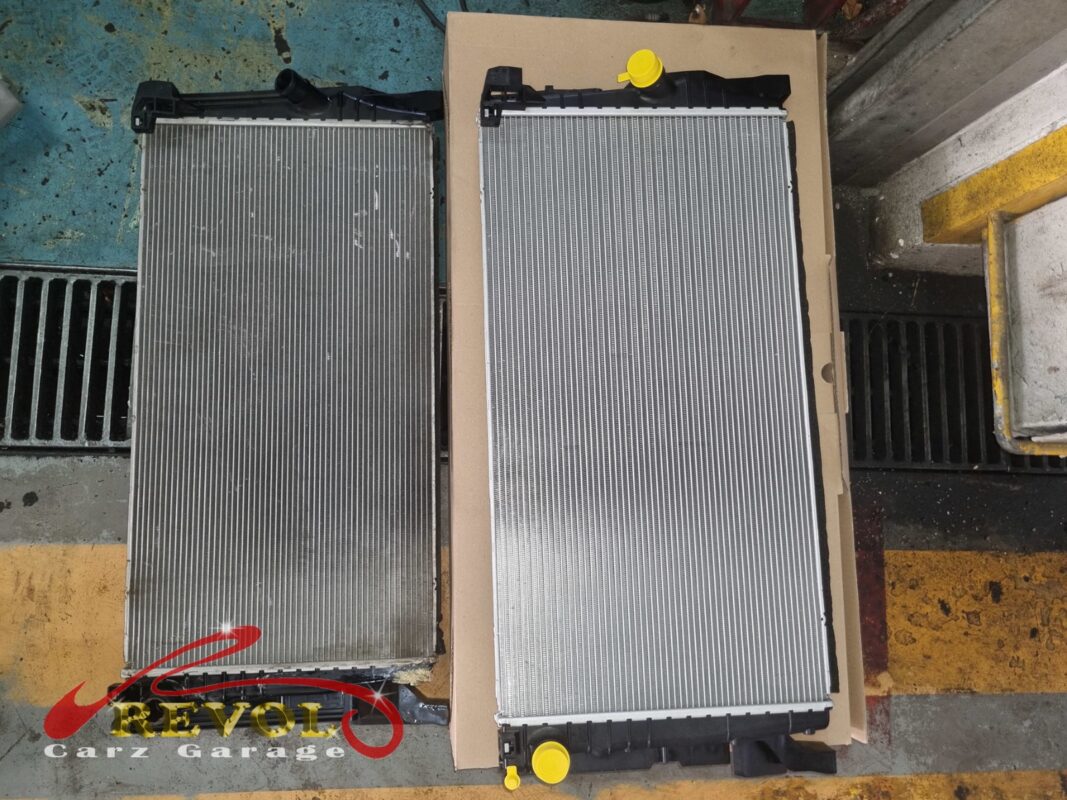 The old radiator (left, grimy) beside the new BMW-spec replacement (right).